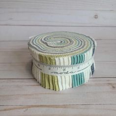 a close up of a roll of fabric on a wooden surface with a measuring tape