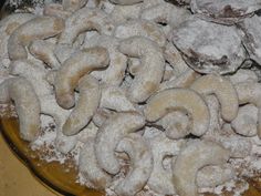 a plate full of doughnuts covered in powdered sugar on a wooden table