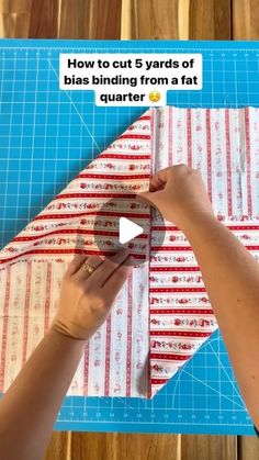 a person cutting up fabric on top of a piece of paper with scissors and tape