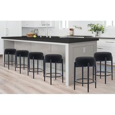 a kitchen island with four stools in front of it