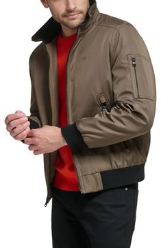 Every closet craves this edgy bomber styled with handy side pockets, a water-resistant finish and comfy ribbed trim. Front zip closure Stand collar Front zip pockets Ribbed cuffs and hem Water resistant Lined 100% polyester Machine wash, line dry Imported Casual Track Jacket With Zipper Closure For Outdoor Activities, Nylon Track Jacket With Zipper Closure For Fall, Casual Nylon Outerwear With Zip Cuffs, Casual Outerwear With Zip Cuffs For Outdoor, Fall Nylon Track Jacket With Zipper Closure, Sporty Calvin Klein Fall Outerwear, Casual Calvin Klein Fall Outerwear, Calvin Klein Casual Fall Outerwear, Dark Tan