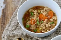 a bowl of soup with carrots, celery and ground beef in it