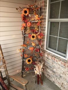 a ladder decorated with sunflowers and fall leaves