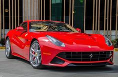 a red ferrari sports car parked in front of a building