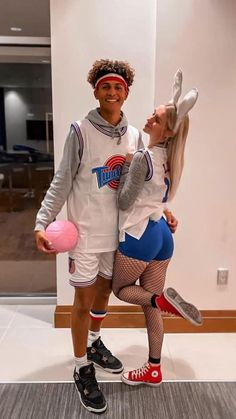 a man and woman dressed in costumes posing for the camera with one holding a pink frisbee