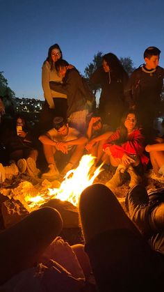 a group of people sitting around a campfire