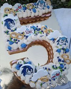 a cake shaped like the letter e is decorated with blue and white frosting, along with an image of sonic