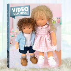 two dolls are standing next to each other in front of a video course book cover