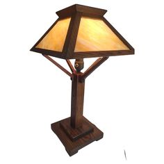 a lamp that is sitting on top of a wooden stand with a white light in the middle