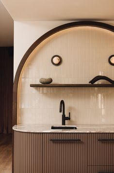 a kitchen with a sink, shelves and lights on the wall above it's countertop