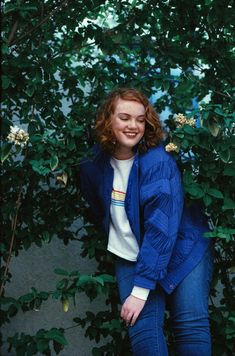 a woman standing in front of a tree