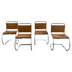 four chairs with leather seats and metal legs