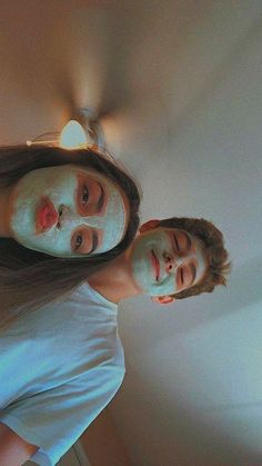 two people standing next to each other in front of a ceiling fan with light on