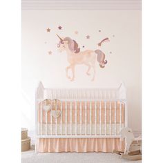 a baby's room with a crib and wall decals