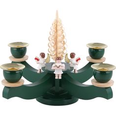 a small figurine is sitting on top of a table with cups and saucers