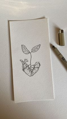 a piece of paper with a drawing of a plant on it next to a marker