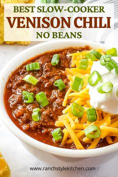 the best slow cooker venison chili no beans in a white bowl with sour cream on top