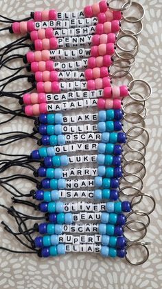 several different colored beads with words written on them are attached to key chains that hang from the wall