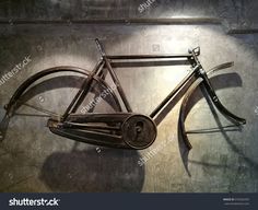 an old bicycle is hanging on the wall with some tools in it's back