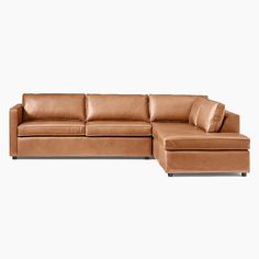 a brown leather sectional sofa sitting on top of a white floor