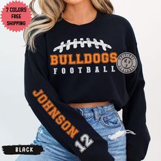 This trendy football team name custom sleeve name crewneck sweatshirt is pure comfort. Combining soft cotton and quality print elements make users fall in love with it over and over again. These garments are made from polyester and cotton. This combination helps designs come out looking fresh and beautiful. The collar is ribbed knit, so it retains its shape even after washing. There are no itchy side seams on these sweaters. .: Made with a medium-heavy fabric blend of 50% cotton and 50% polyester (8.0 oz/yd² (271.25 g/m this sweatshirt feels cozy and is the perfect choice for those colder months. .: The classic fit along with the crew neckline deliver a comfy wearing experience with a clean-cut style. Meanwhile, the double-needle stitching at the shoulder, armhole, neck, waistband, and cuf Sporty Football Season Sweatshirt With Team Name, Football Season Fan Apparel Sweatshirt With Team Name, Black Sweatshirt With Football Team Name, Football Season Name Print Crew Neck Tops, Team-colored Graphic Print Sweatshirt For Football Season, Football Players Names, Football Team Names, Bulldogs Football, Personalized Football