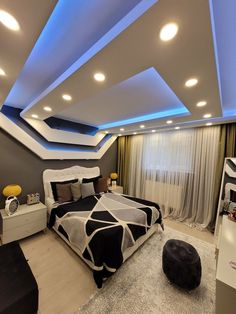 a modern bedroom with black and white bedding, grey walls and ceiling lights above the bed