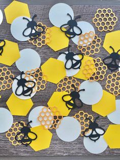 paper honeycombs and scissors are arranged on a wooden table with yellow hexagons