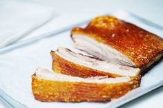 slices of meat sitting on top of a white plate