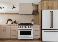 a white stove top oven sitting inside of a kitchen next to a refrigerator freezer