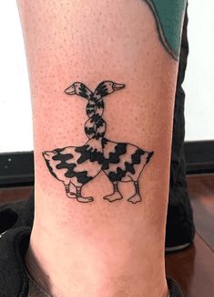 a black and white cow tattoo on the leg by a person's foot,