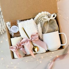 a box filled with white items on top of a table next to a pink ribbon