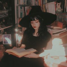 a woman sitting in front of a bookshelf with a book on her lap