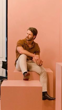 a man sitting on top of a pink box