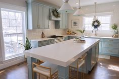 a kitchen with blue cabinets and white counter tops