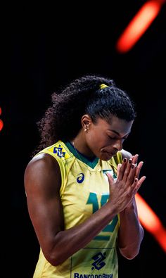 a woman in yellow shirt holding her hands together