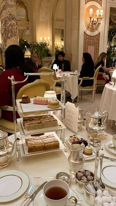 the table is set with tea and desserts