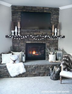 a living room with a fire place and christmas decorations on the mantel above it