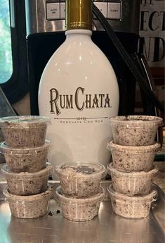 some cups are sitting on the counter next to a rumchata bottle and coffee pot