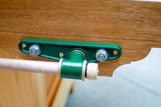 a green handle is attached to a wooden table