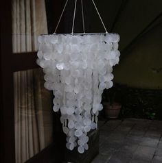 a chandelier made out of plastic bottles hanging from it's sides in a room