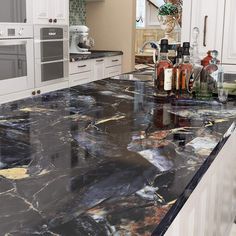 a kitchen with marble counter tops and white cabinets