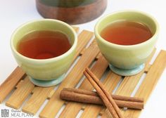 there are two cups of tea and cinnamon sticks