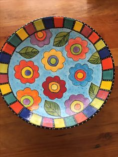 a colorful plate sitting on top of a wooden table