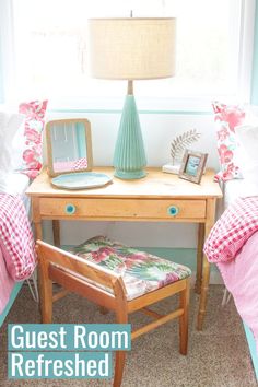 a small desk with a mirror and lamp on it