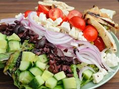 a salad with tomatoes, cucumbers, onions and other vegetables on a plate