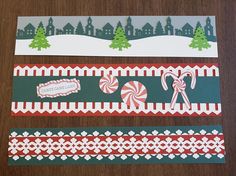 three christmas themed paper strips with candy canes and candies on them sitting on a table