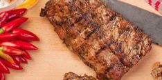 the steak is ready to be cooked on the cutting board with red peppers around it