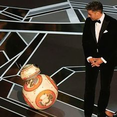 a man in a tuxedo standing next to a star wars bball