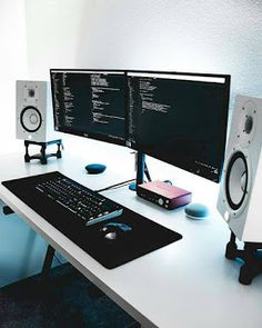 two computer monitors sitting on top of a desk next to a keyboard and mouse with speakers