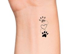 a small tattoo on the wrist of a person with a dog's paw and heart